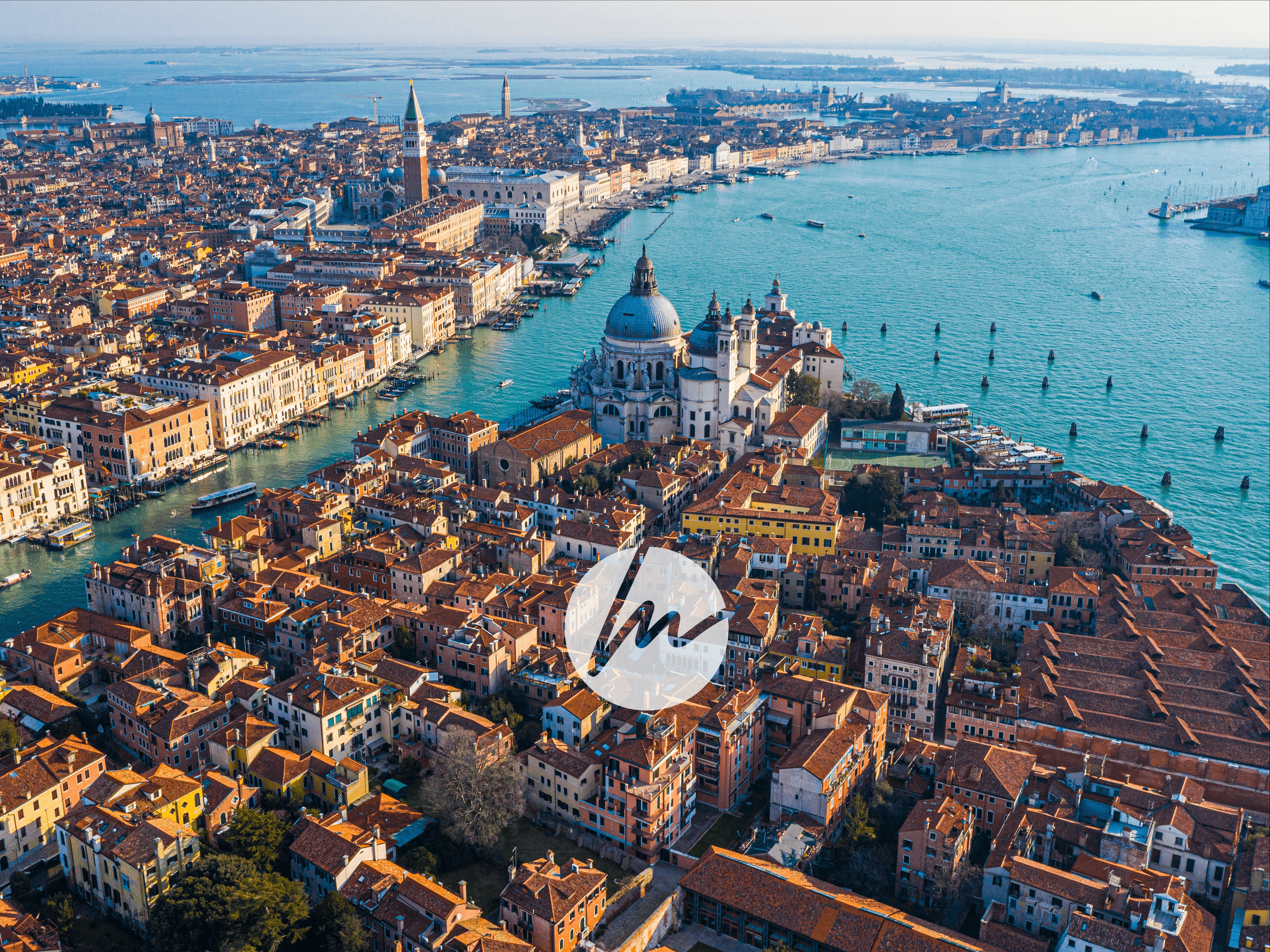 Veduta aerea di Venezia con la Basilica della Salute, il Canal Grande e tetti rossi.